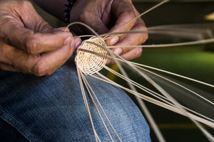 Fingers of artisan weaving sustainable wicker rattan handicrafts in the Philippines