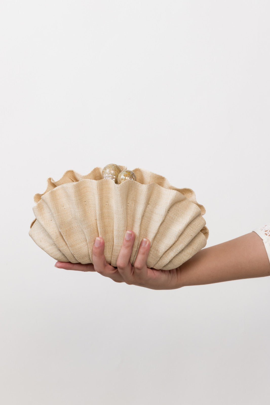 Handcrafted Josephine Clamshell Clutch Beige made from T'boli tribe tinalak fabric, featuring shell-encrusted ball accents. A sustainable, elegant accessory for weddings, evening events, and gifts.