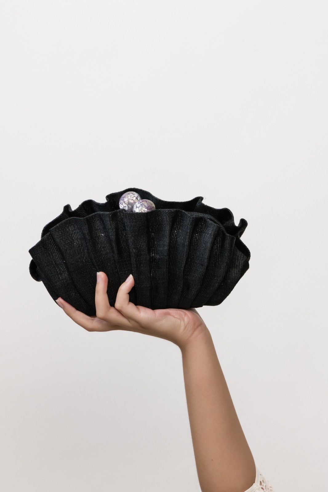 Handcrafted Josephine Clamshell Clutch Black made from T'boli tribe tinalak fabric, featuring shell-encrusted ball accents. A sustainable, elegant accessory for weddings, evening events, and gifts.