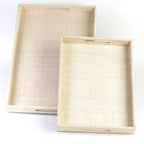 Adie Positively Simple Decorative Trays Set of 2 made from natural plant fibers, displayed on a table with decorative items, showcasing eco-friendly design and multi-purpose functionality for serving and organizing.