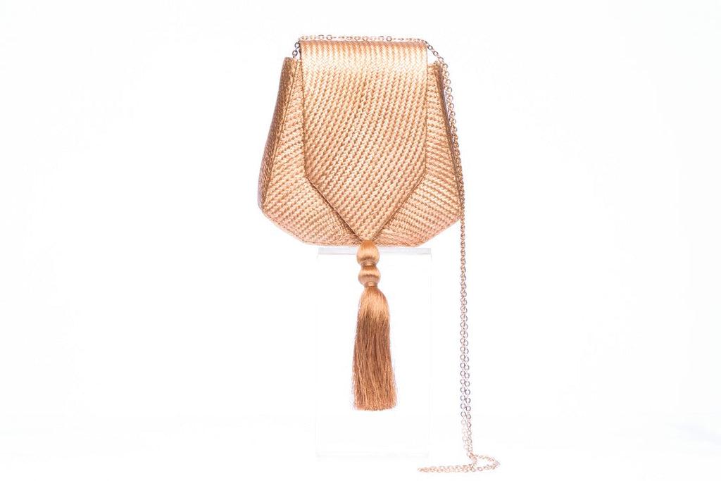 Bronze Glory Shoulder Bag, a handwoven clutch made from 100% natural plant fibers, showcasing sustainable luxury and elegance. This eye-catching bag features a lustrous bronze finish, a gold tassel for added flair, and a brass drop-in chain strap for versatile carrying. Perfect for garden weddings and fancy dinners, the fully lined interior is designed to organize essentials like mobile phones, credit cards, and lipstick.