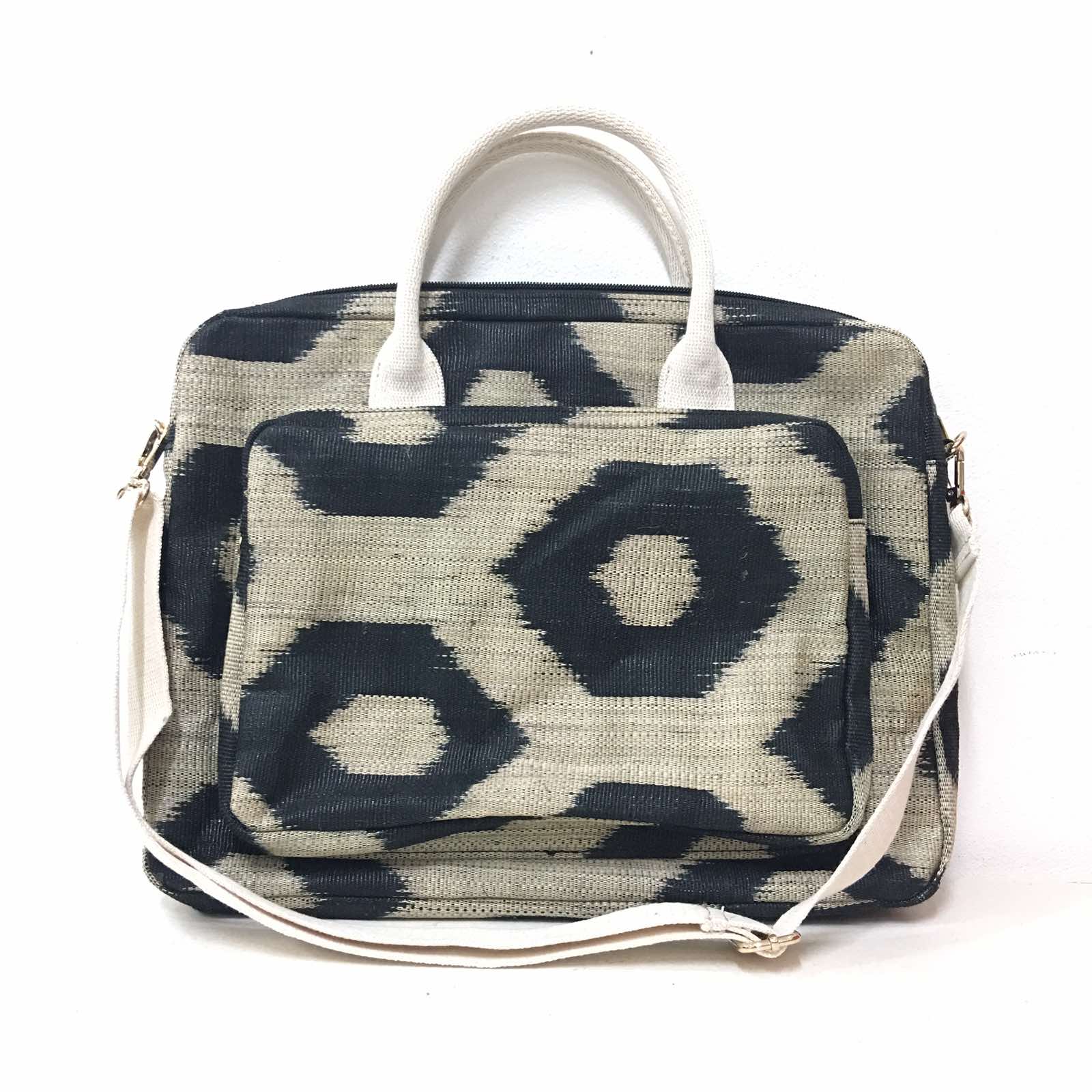 Deidre Black Turtle T'nalak Laptop Bag made from traditional T'nalak fabric, handwoven by the Tboli tribe in Mindanao using sustainable abaca plant fiber. This eco-friendly laptop bag accommodates devices up to 14 inches, blending heritage and modern utility with adjustable cotton straps. Durable 50% polyester and 50% cotton body. Spot clean for best care.