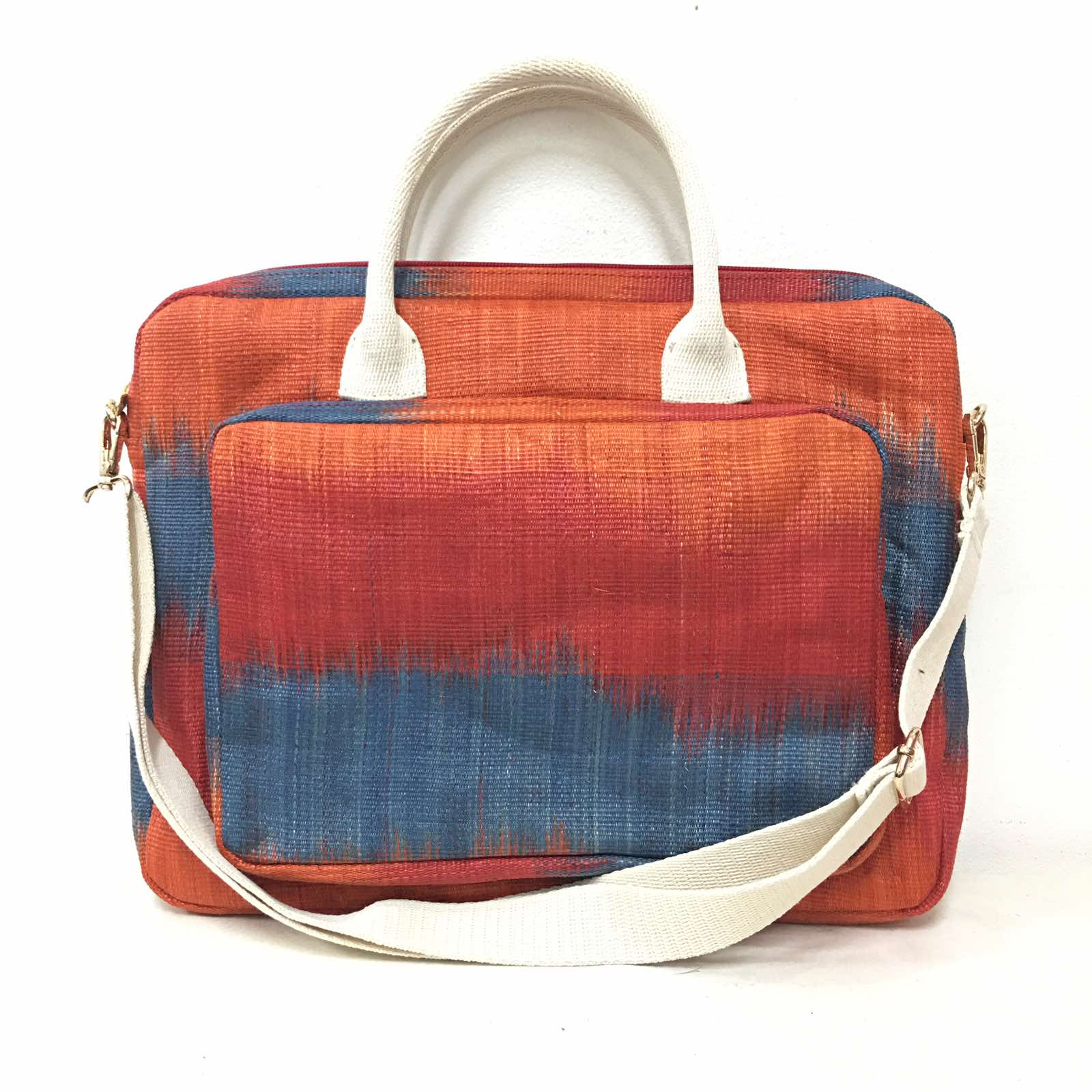Deidre Red Skies T'nalak Laptop Bag made from traditional T'nalak fabric, handwoven by the Tboli tribe in Mindanao using sustainable abaca plant fiber. This eco-friendly laptop bag accommodates devices up to 14 inches, blending heritage and modern utility with adjustable cotton straps. Durable 50% polyester and 50% cotton body. Spot clean for best care.