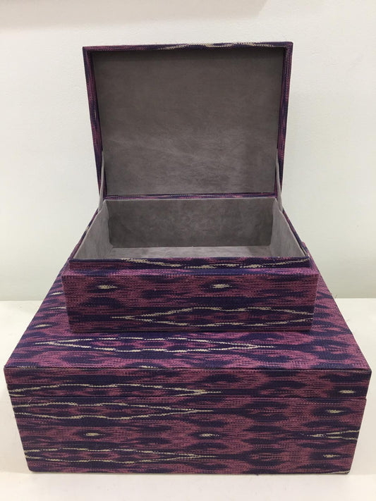 Mia Storage Boxes Set of 2 - Peacock, featuring handwoven tinalak fabric in vibrant colors, displayed on a wooden shelf with organized essentials.