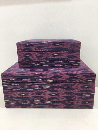 Mia Storage Boxes Set of 2 - Peacock, featuring handwoven tinalak fabric in vibrant colors, displayed on a wooden shelf with organized essentials.