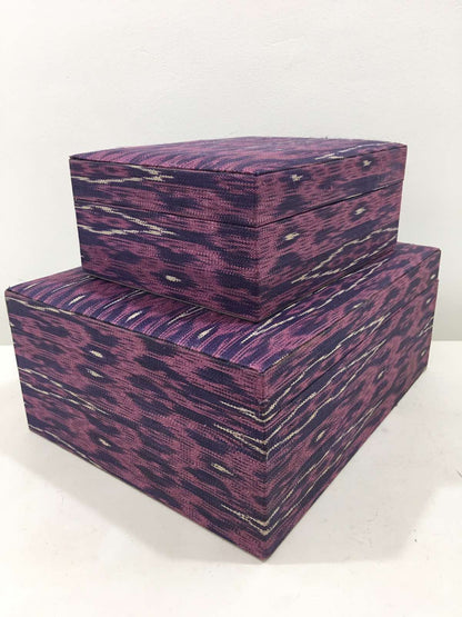 Mia Storage Boxes Set of 2 - Peacock, featuring handwoven tinalak fabric in vibrant colors, displayed on a wooden shelf with organized essentials.